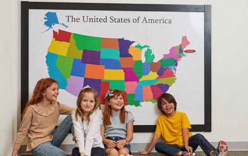 Four children sitting in front of Slab Dream Lab custom printed USA map baseplate