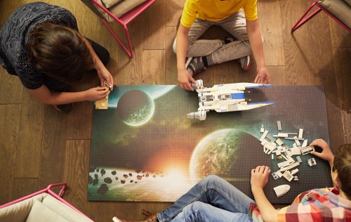 children playing with toy spaceship on a Slab dream lab custom printed Space and Planets baseplate